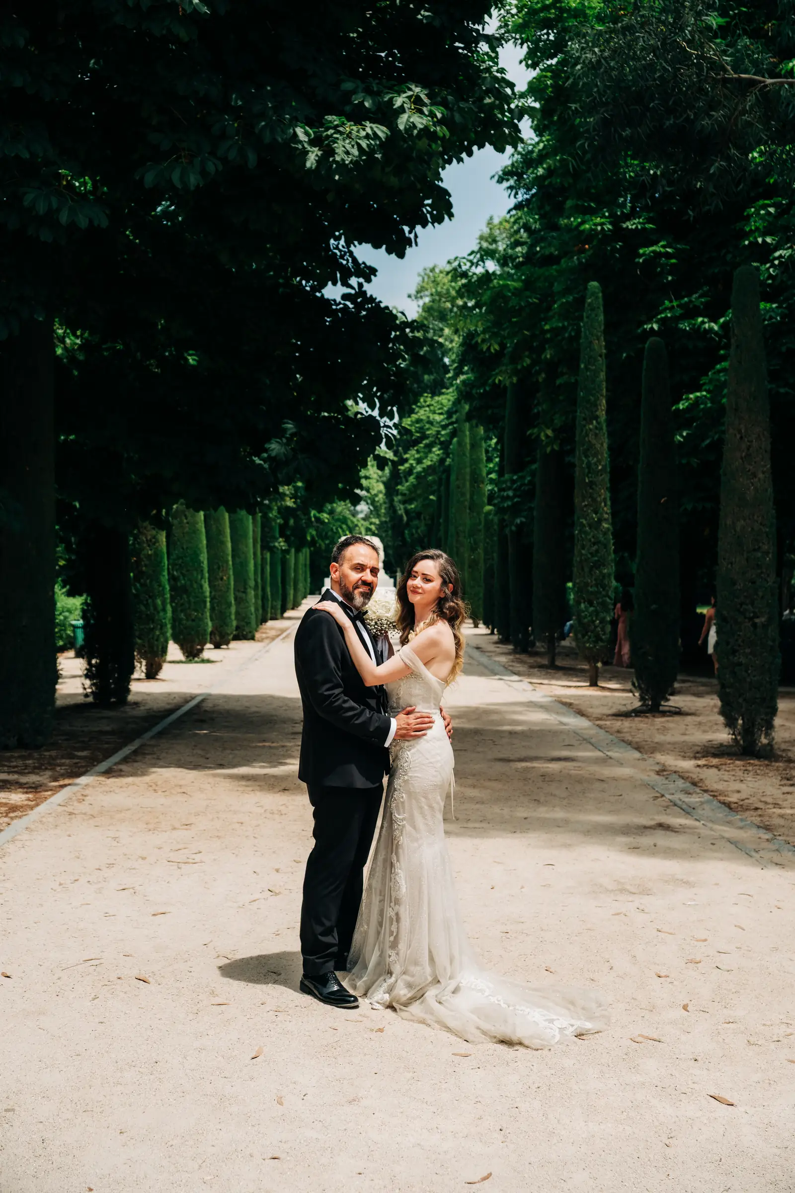 Couple embracing in a long cypress alley in Madrid